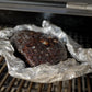 Brisket wrapped in foil on the smoker, probed for temperature
