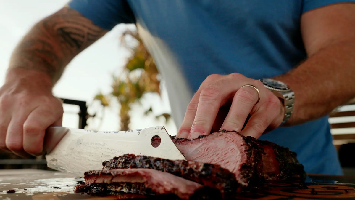 Ty slicing smoked Trisket on a cutting board